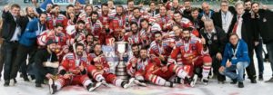 Hockeyteam mit den Managern, die den Sieg mit einem Pokal feiern