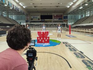 Fotograf, der ein Foto von drei Spielern mit dem Sparkasse-Logo im Vordergrund macht