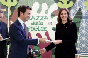 Ein Mann überreicht Camilla Lunelli den Preis als Meisterin der Verantwortung.
