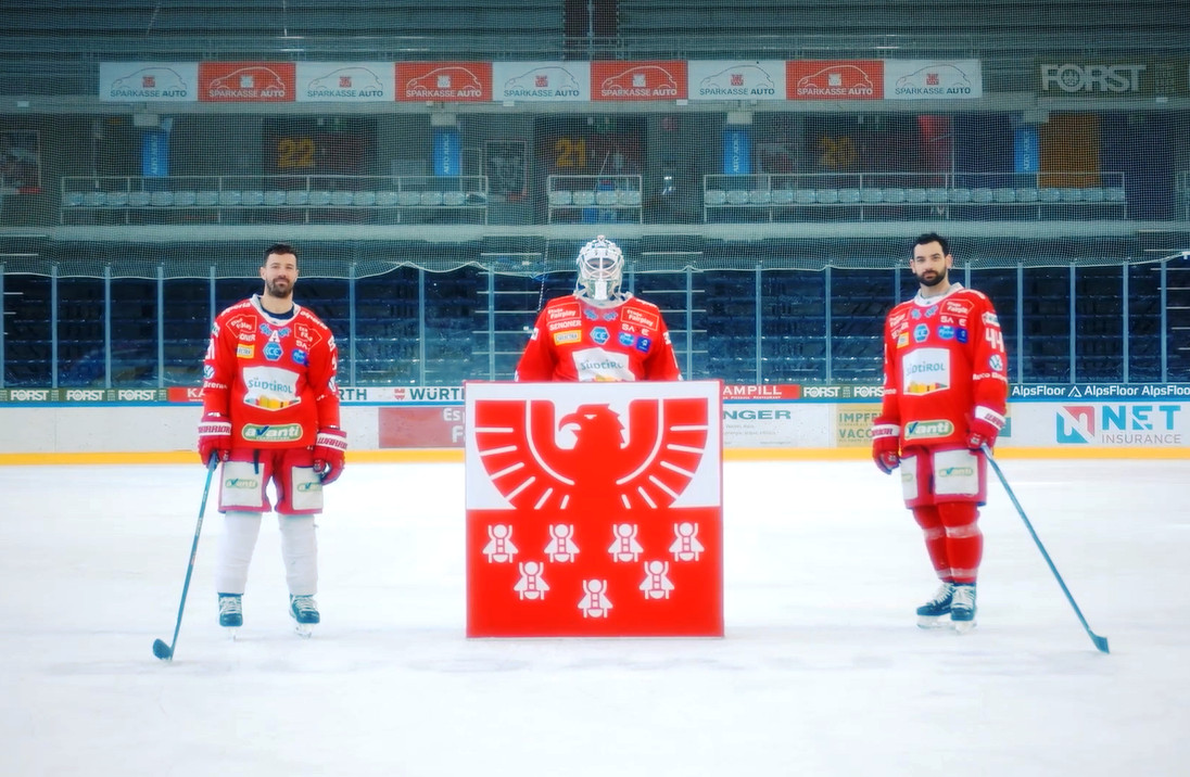 3 Eishockeyspieler der Bozen Foxes mit dem Sparkasse-Logo im Vordergrund