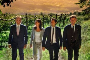 Marcello, Matteo, Camilla und Alessandro Lunelli spazieren durch einen Weinberg.