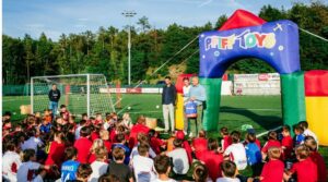 Viele Kinder sitzen auf einem Fußballfeld