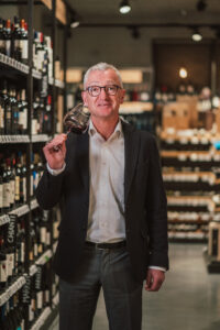 Günther Maier mit einem Glas Rotwein in der Hand